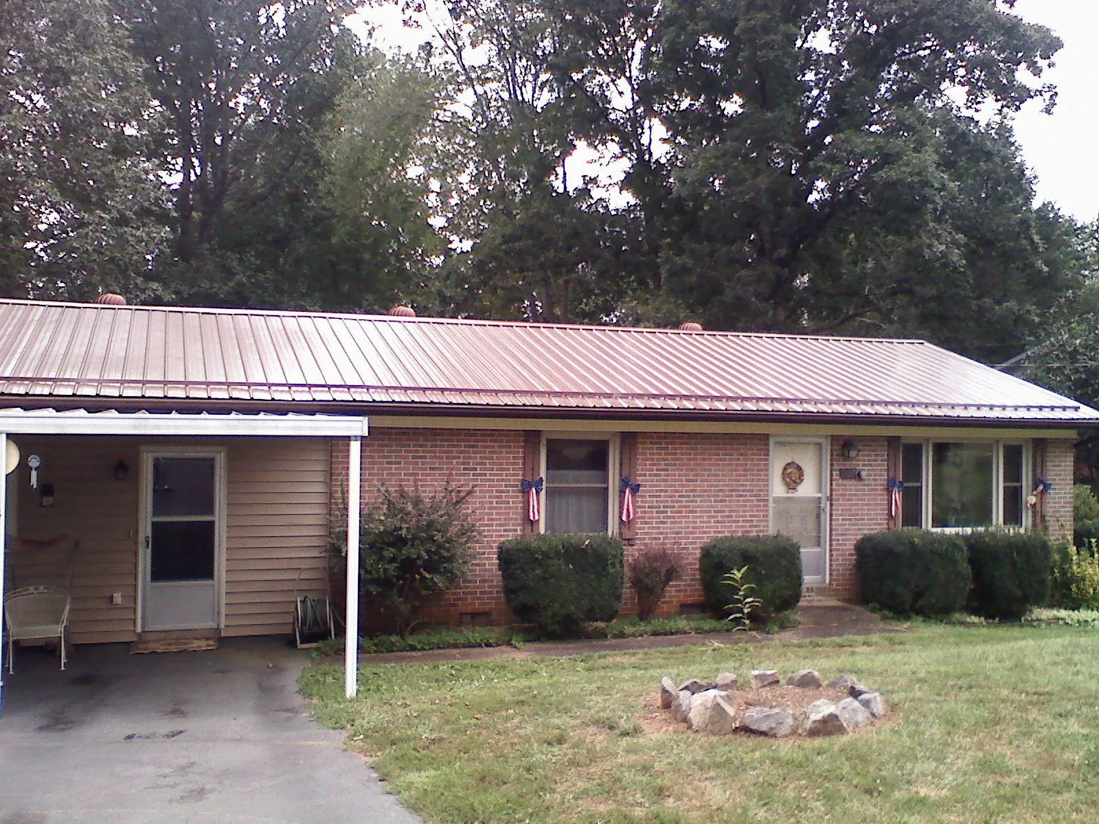 Bronze metal roof and carport on a brick ranch home — Roof Repair work by our crew in Persia